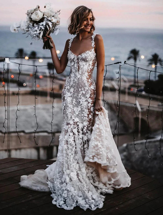 Bride in a mermaid trumpet wedding dress with sweetheart neckline and lace appliques, front view.