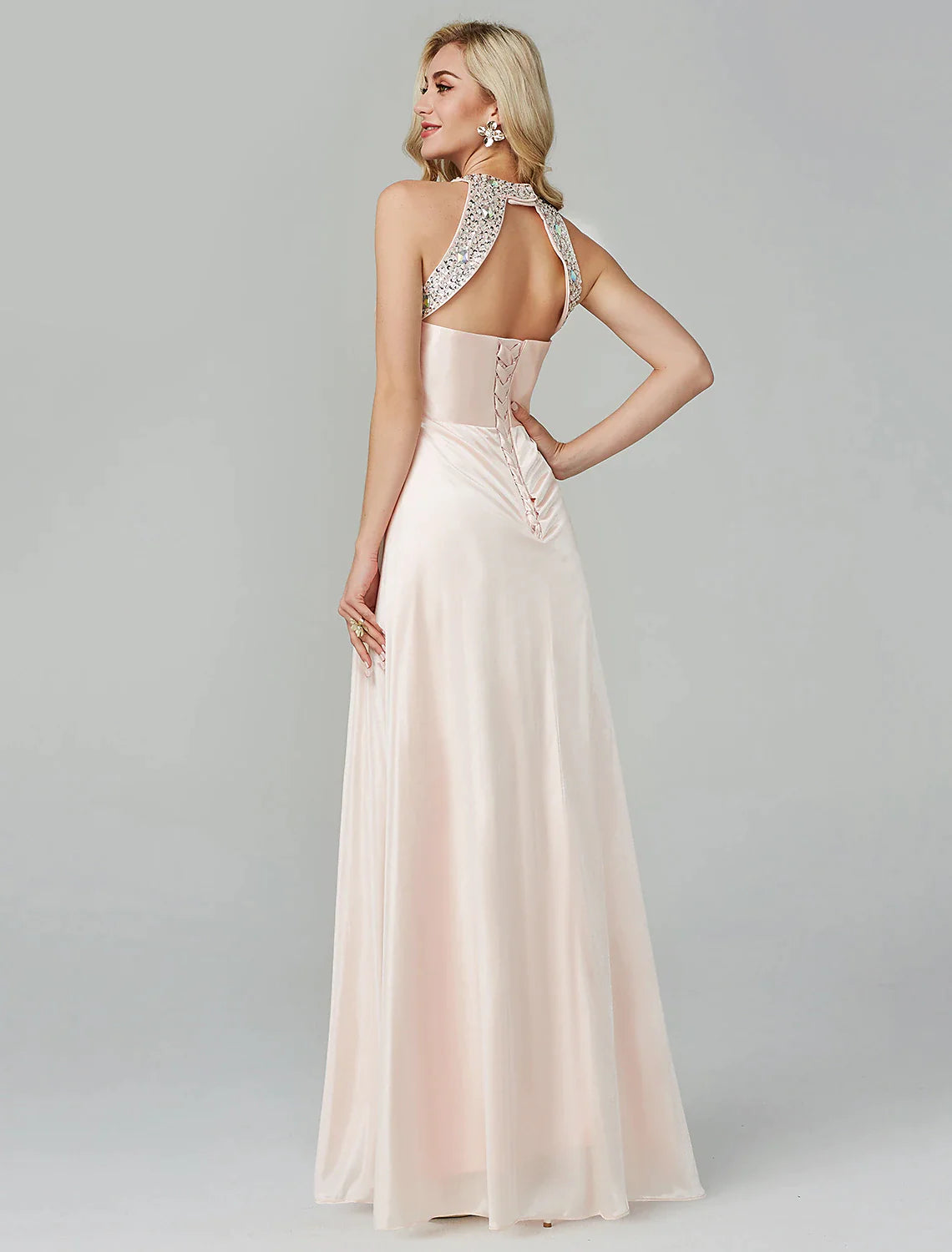 Side profile of the model in the flowing black A-line evening dress.