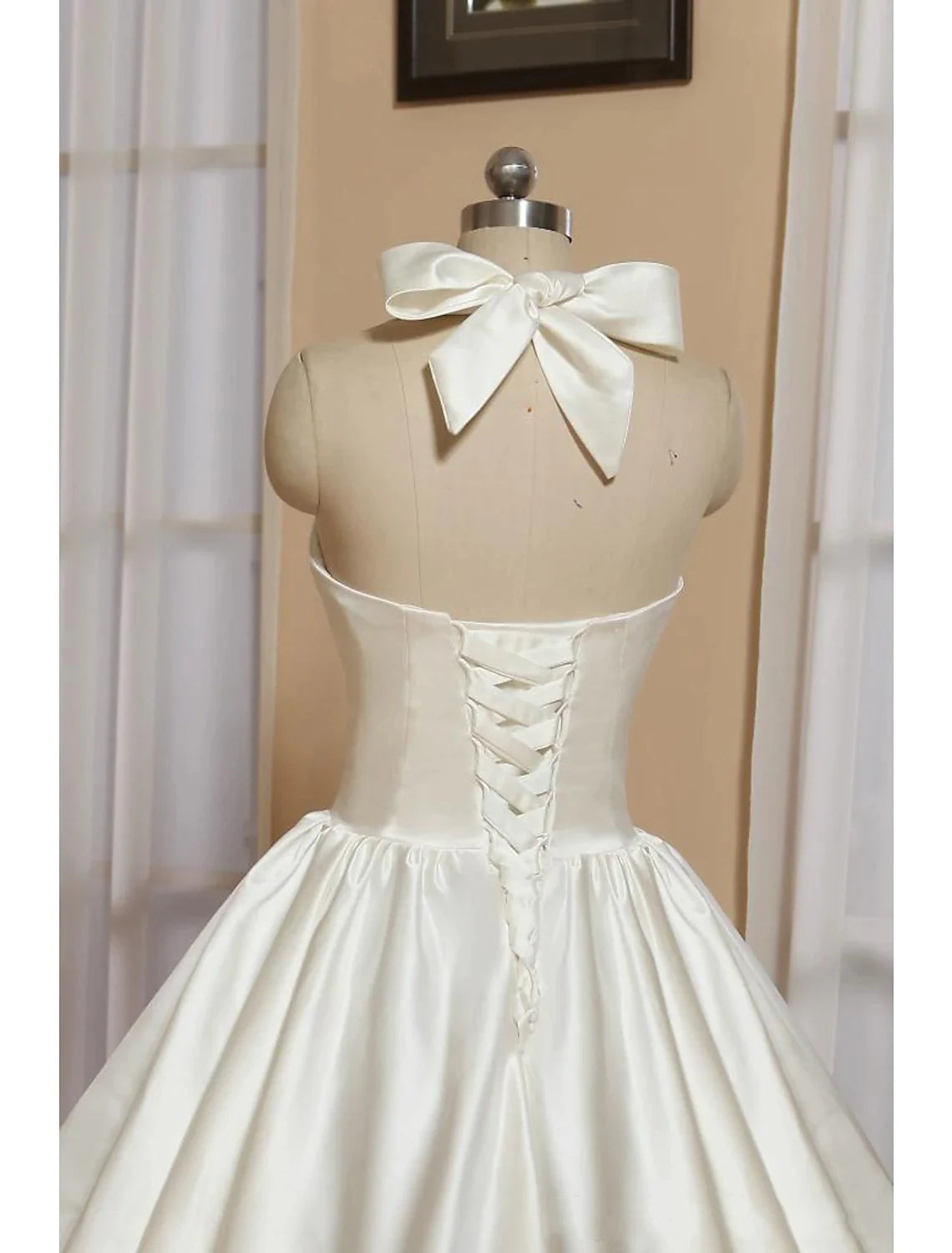 Side view of the satin tea-length bridal gown with halter neckline.