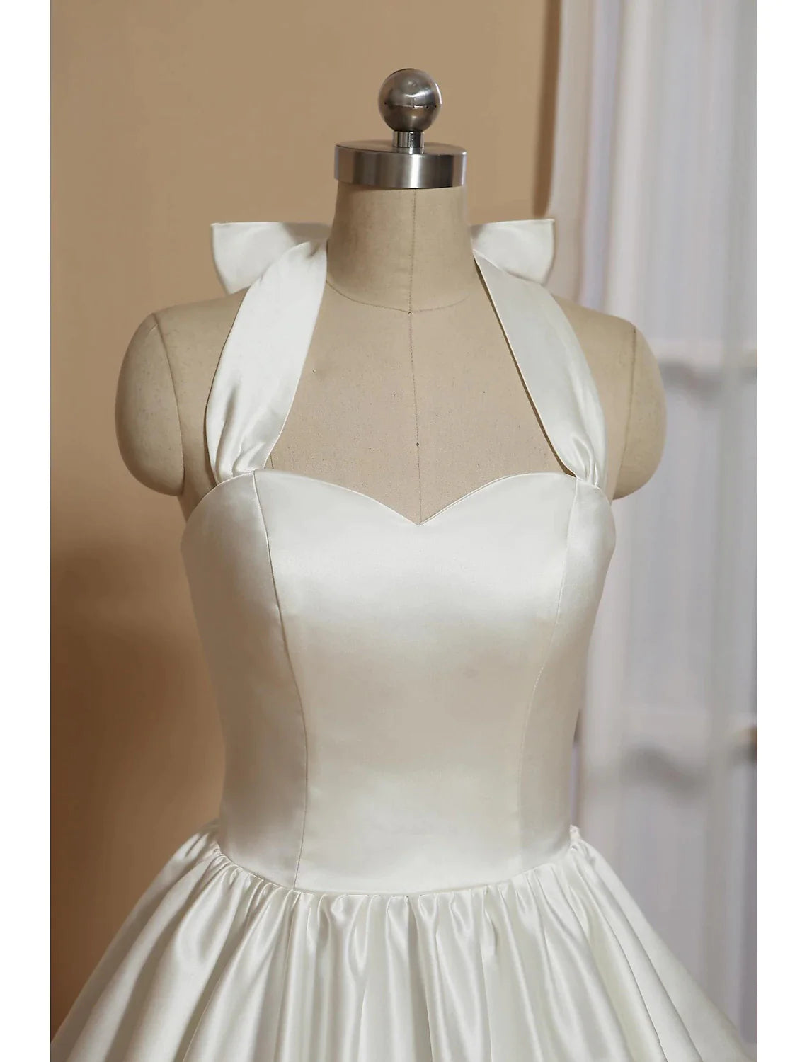Close-up of the bow detail on the elegant little white reception dress.