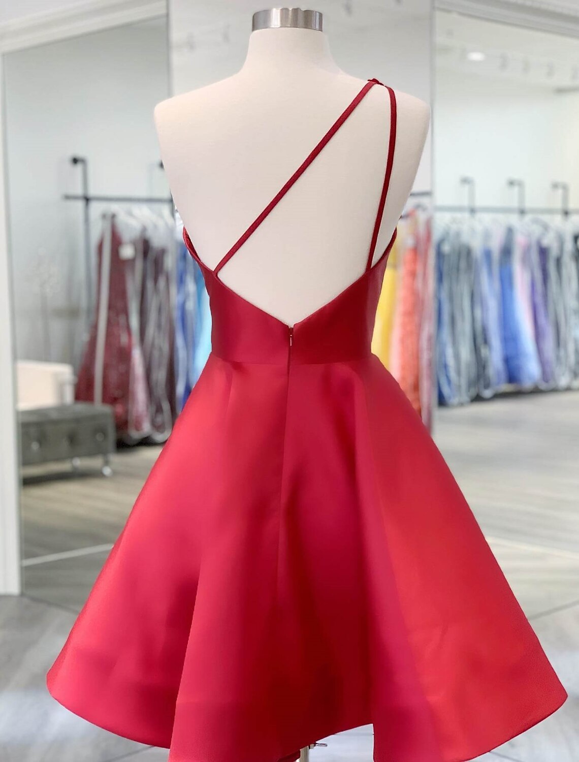 Close-up of appliques on a one-shoulder satin homecoming dress.