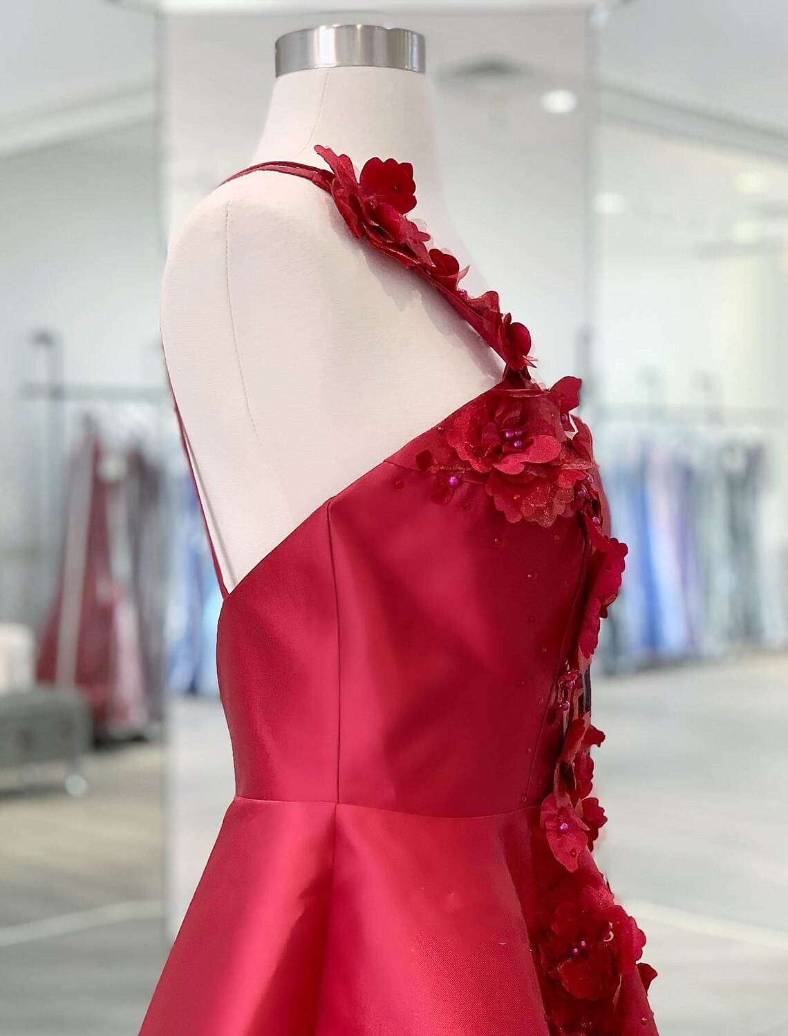 Side view of a short A-Line satin dress with one shoulder.