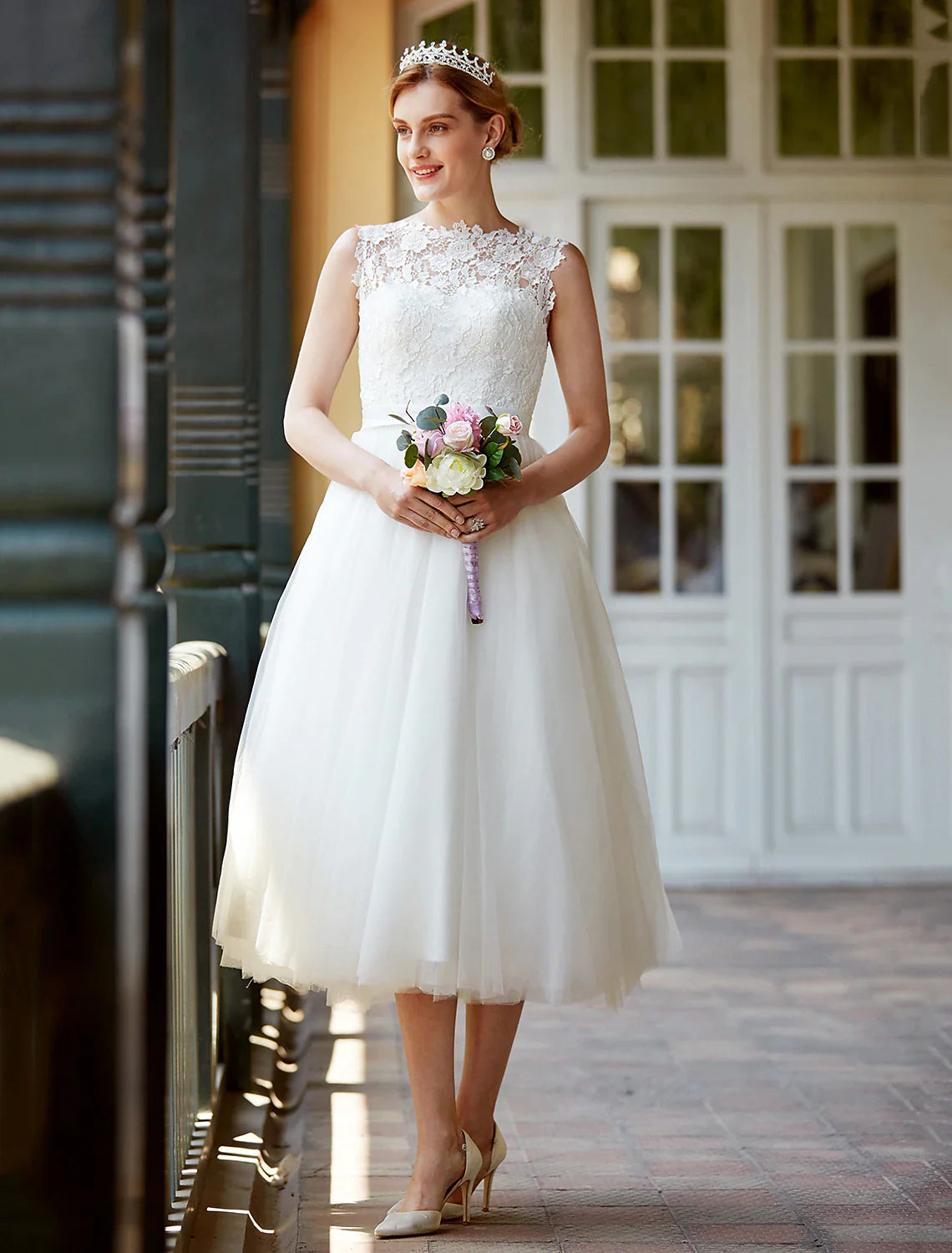Model wearing an elegant A-Line illusion neck lace tea length white bridal gown.
