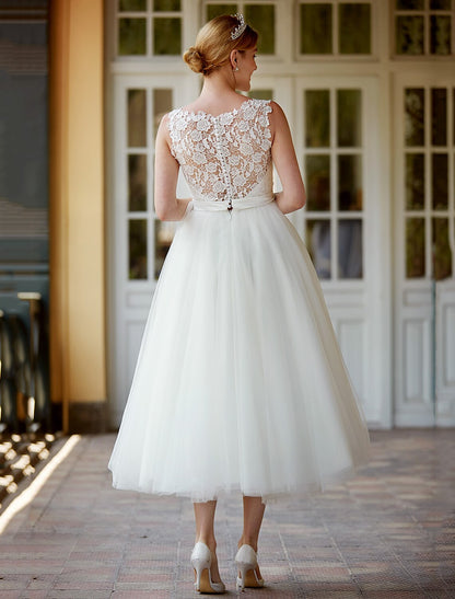 Side profile of the lace tea length white reception dress.
