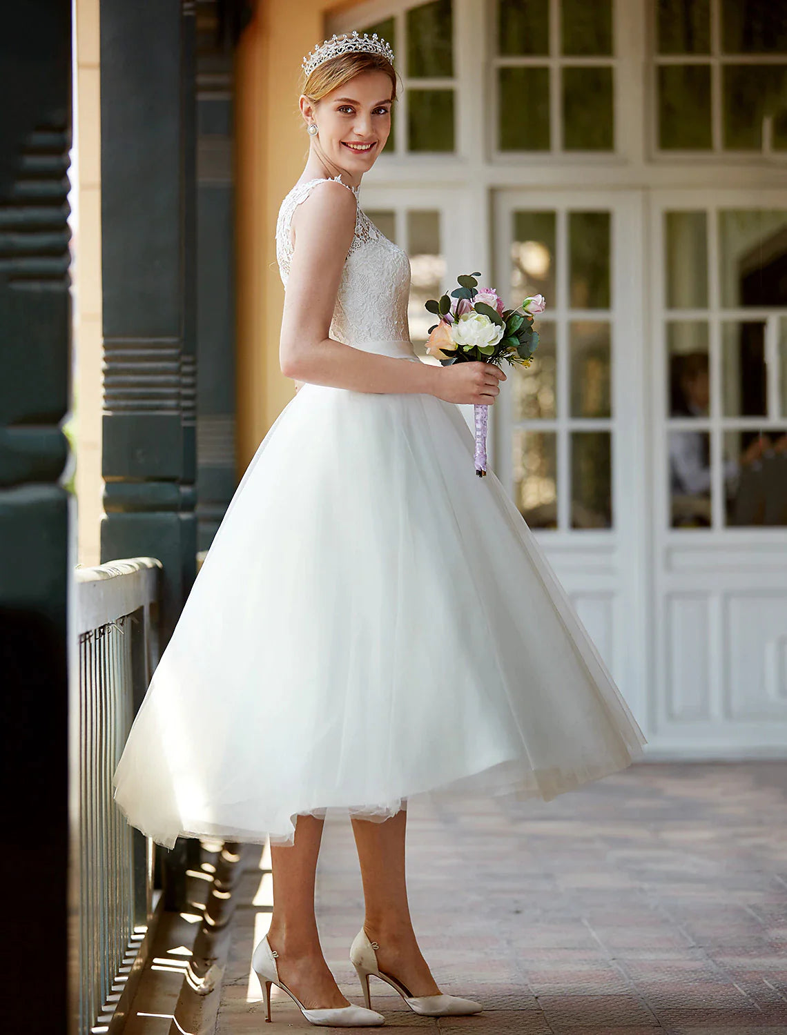 Full view of the tea length white bridal gown with sashes.