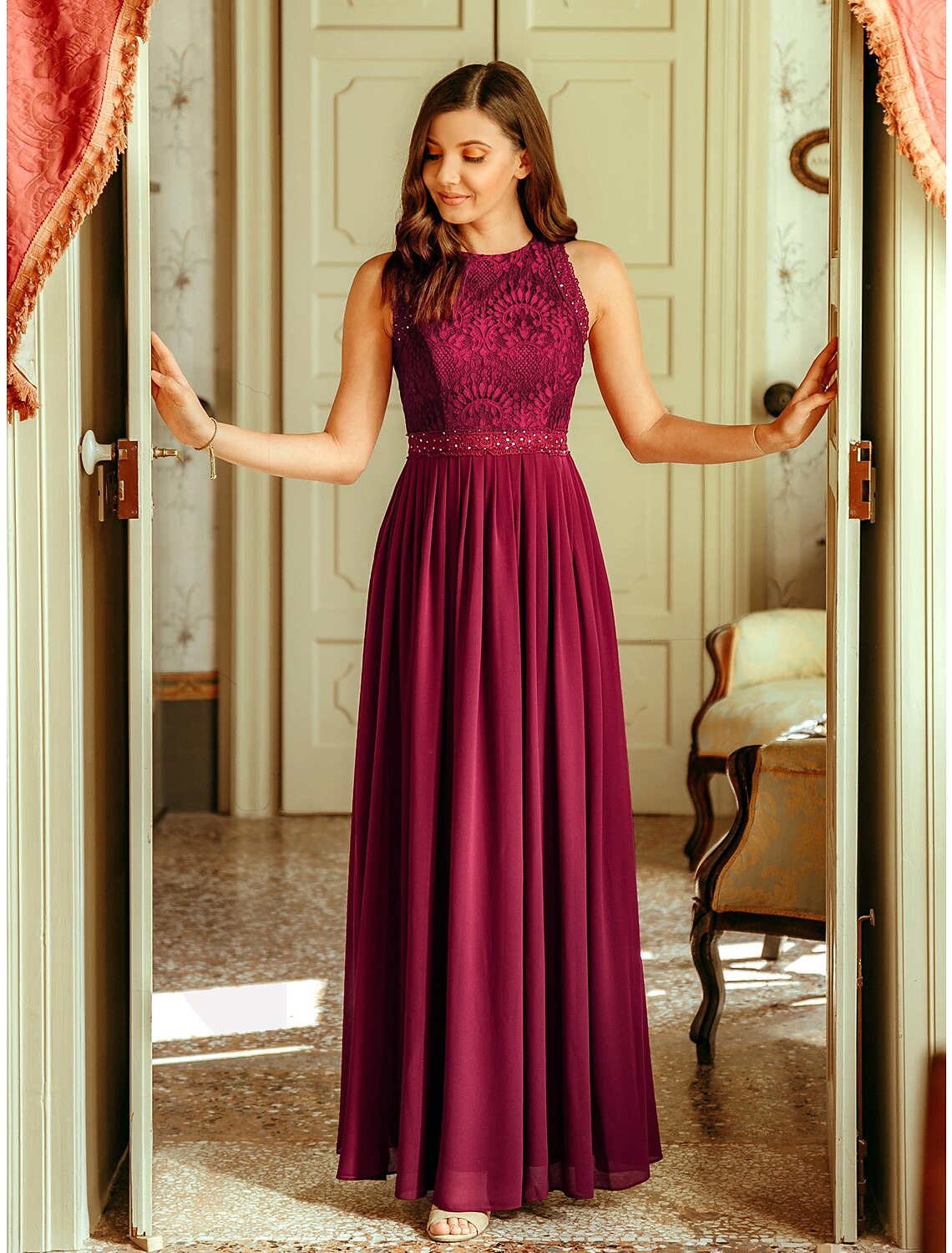 Model wearing a light blue A-line chiffon maxi dress with a jewel neck and pleats.