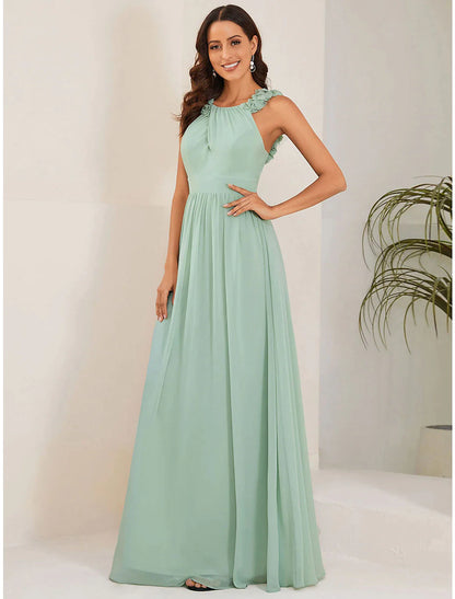 Woman in elegant light blue A-line chiffon wedding guest dress with jewel neck and shoulder flower.
