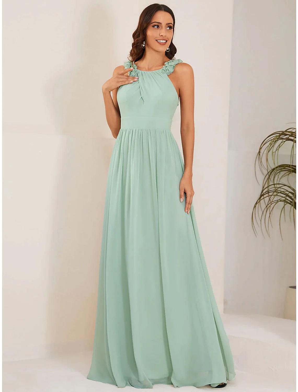 Close-up of the jewel neck and shoulder flower detail on an A-line chiffon dress.