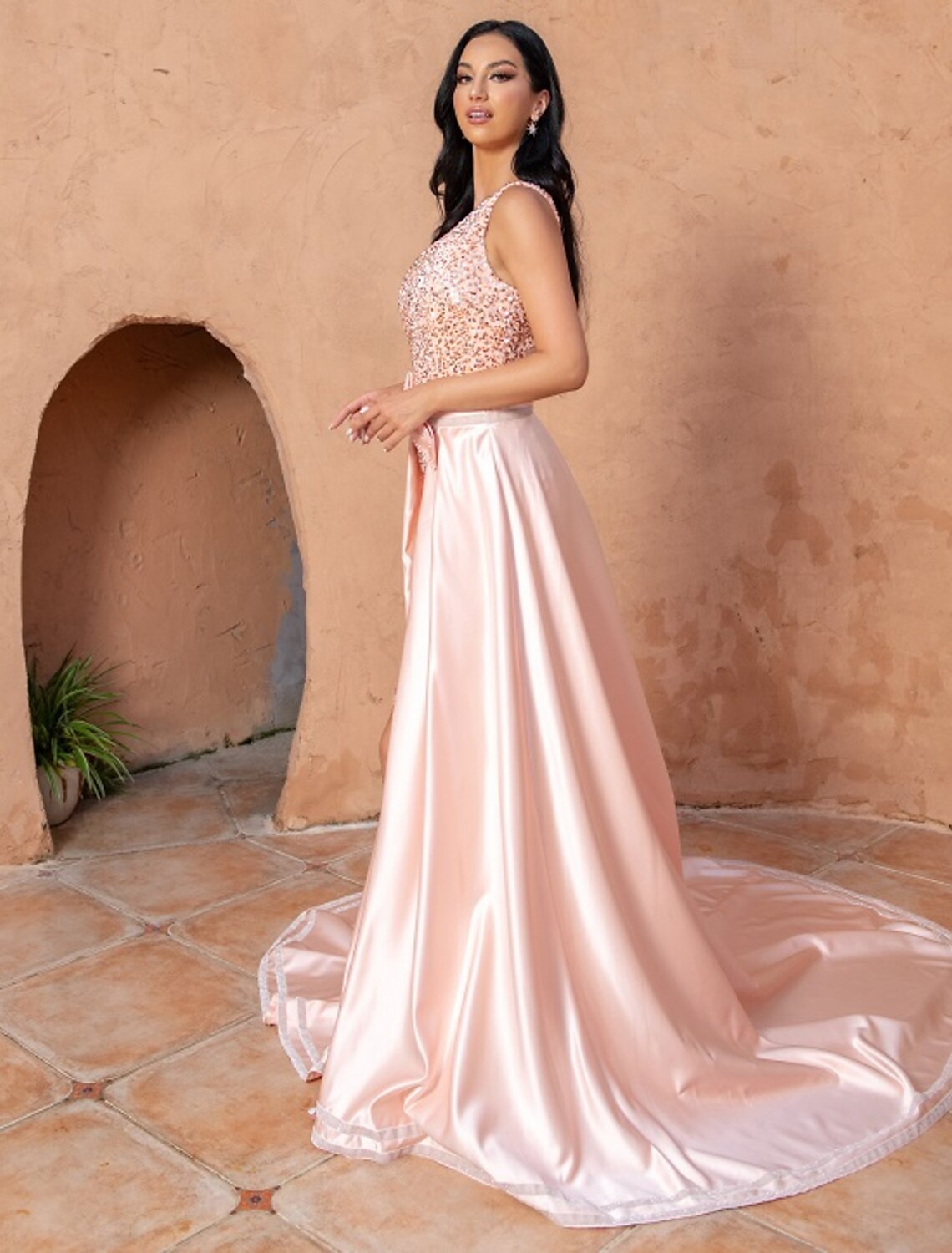 Elegant plus size A-line evening gown with one shoulder and sequin slit on a model.