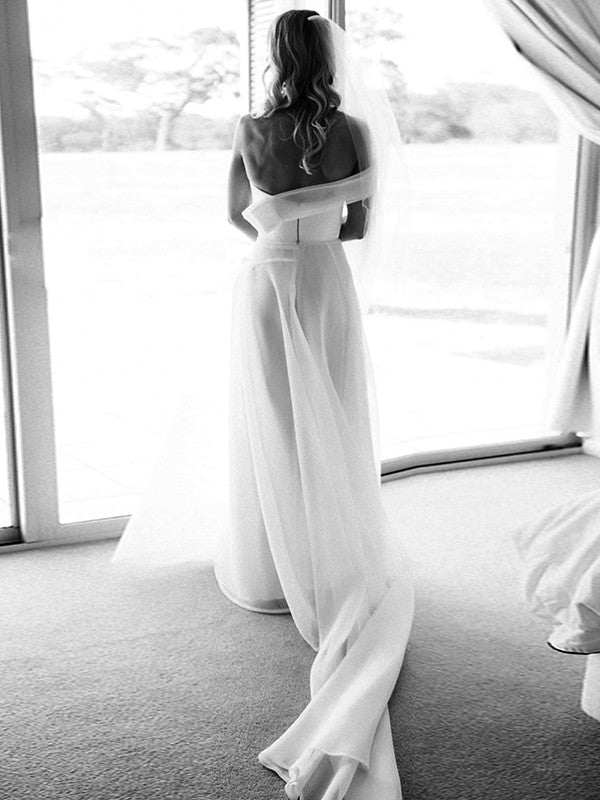 Side view of the A-Line organza wedding dress, highlighting the one-shoulder detail and flowing court train.