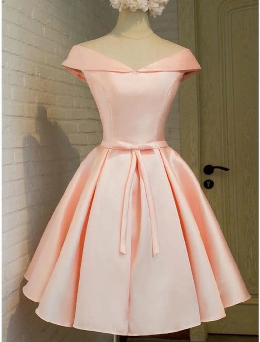 Model wearing an elegant A-line short satin homecoming dress with off-shoulder and strappy details.