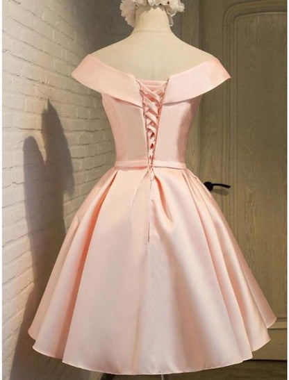 Back view of a model in a short A-line satin dress, showcasing the off-shoulder and strappy design.