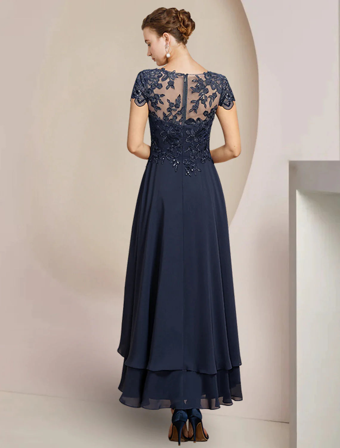 Navy A-Line formal dress with high-low tea length hem and lace details.