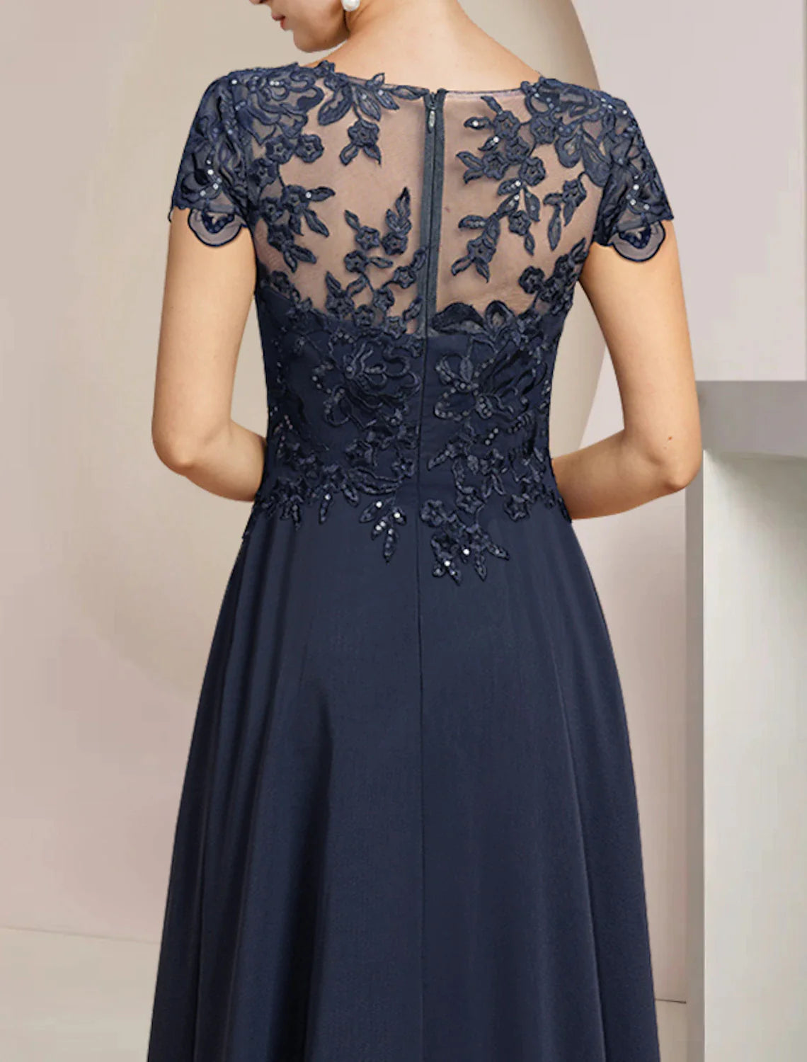 Back view of a sophisticated navy Mother of the Bride dress with sequin appliques.
