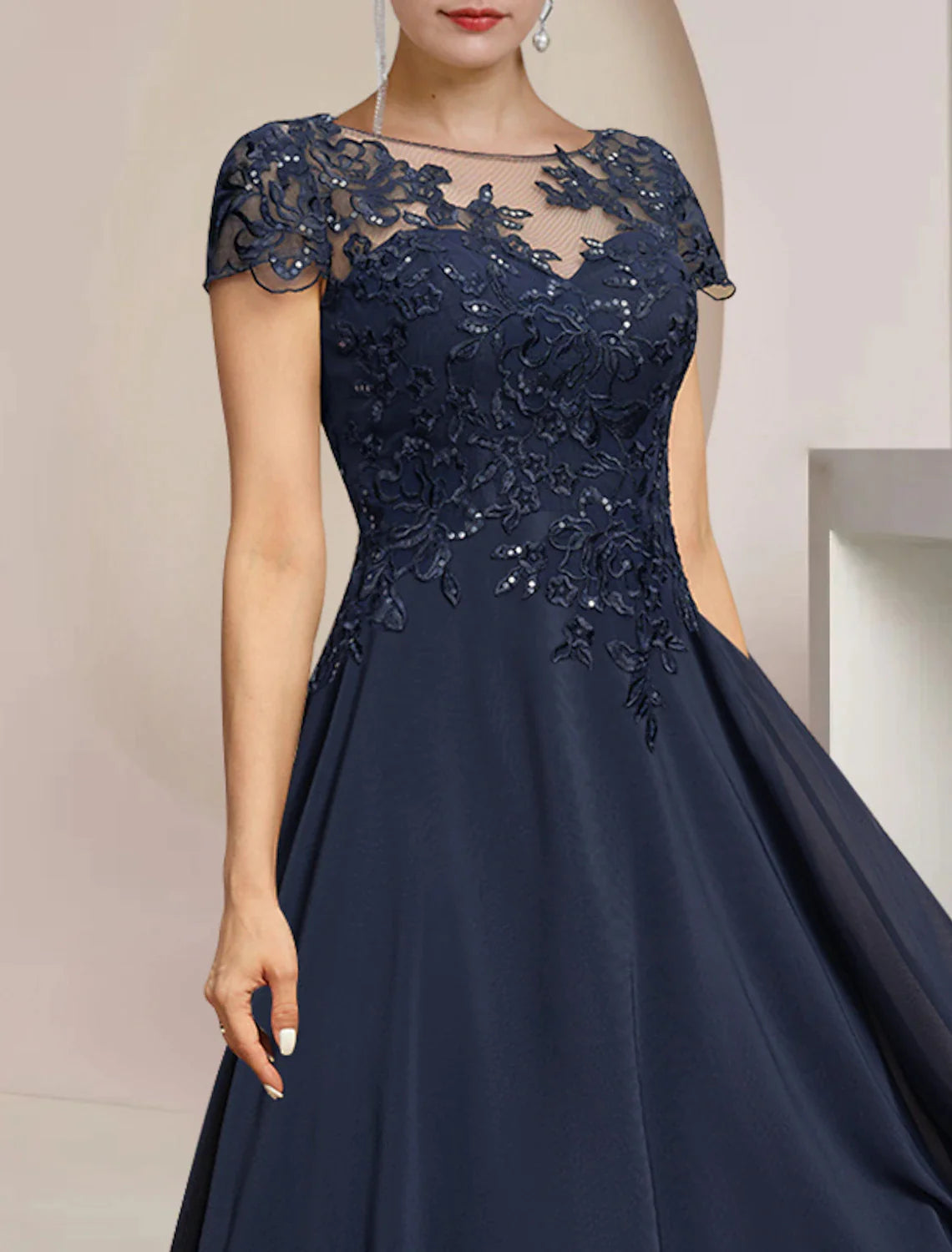 Close-up of the navy A-Line dress showing lace and sequin appliques on the bodice.