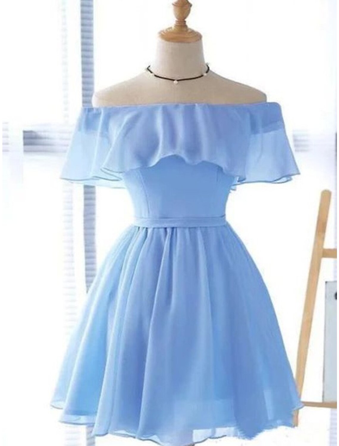 Close-up view of the off-shoulder neckline and ruffled details on the A-line short dress.