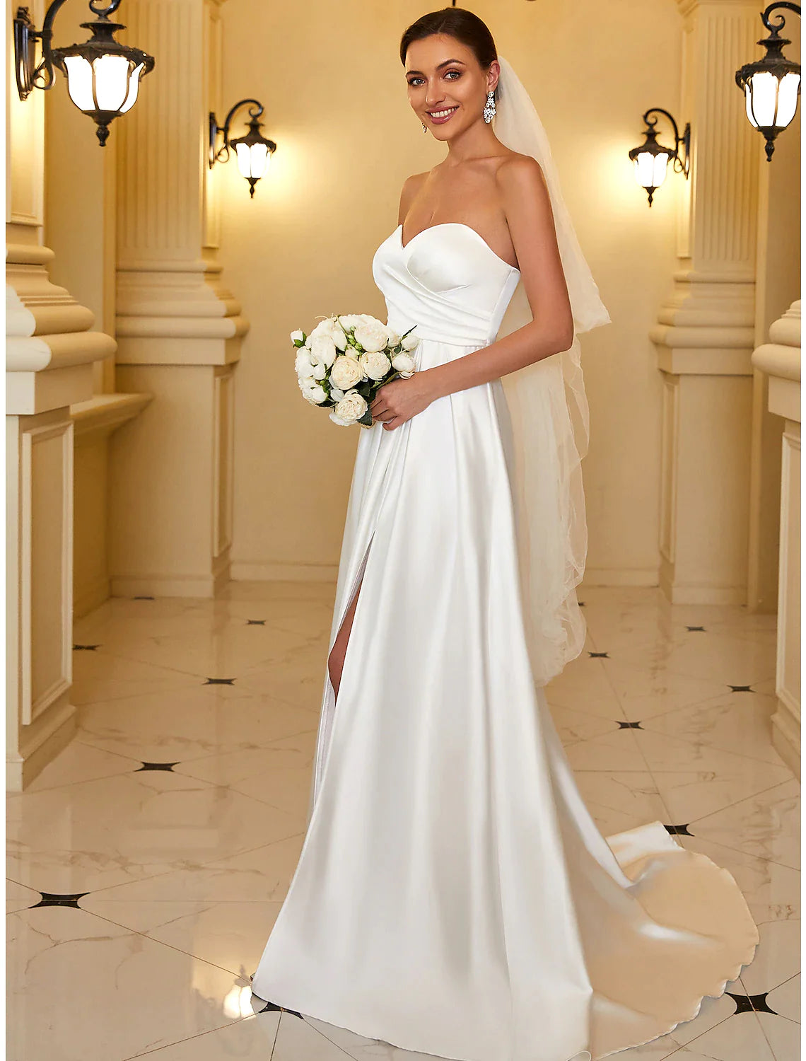 Model wearing an elegant A-line strapless satin evening gown, side view.