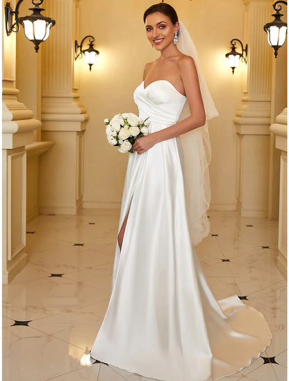 Model wearing an elegant A-line strapless satin evening gown, side view.