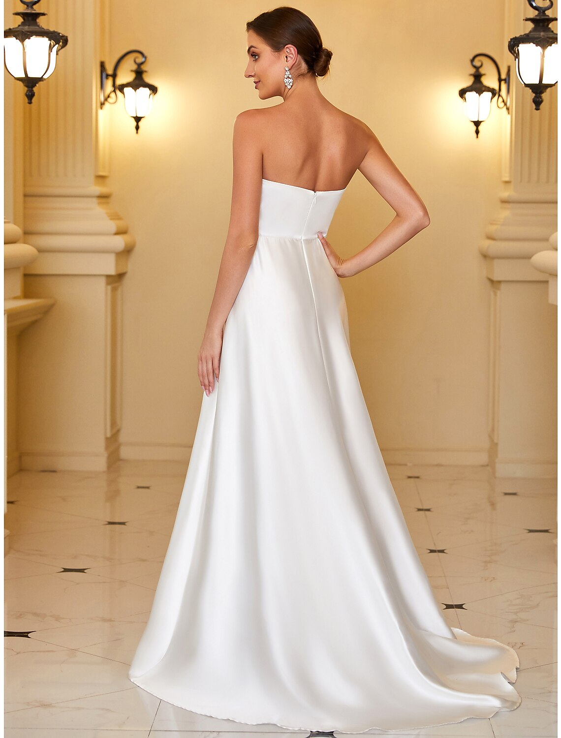 Model wearing an elegant A-line strapless satin evening gown, back view showing backless detail.