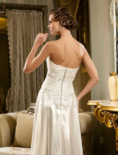 Back view of the white wedding dress, showing button closure and train.