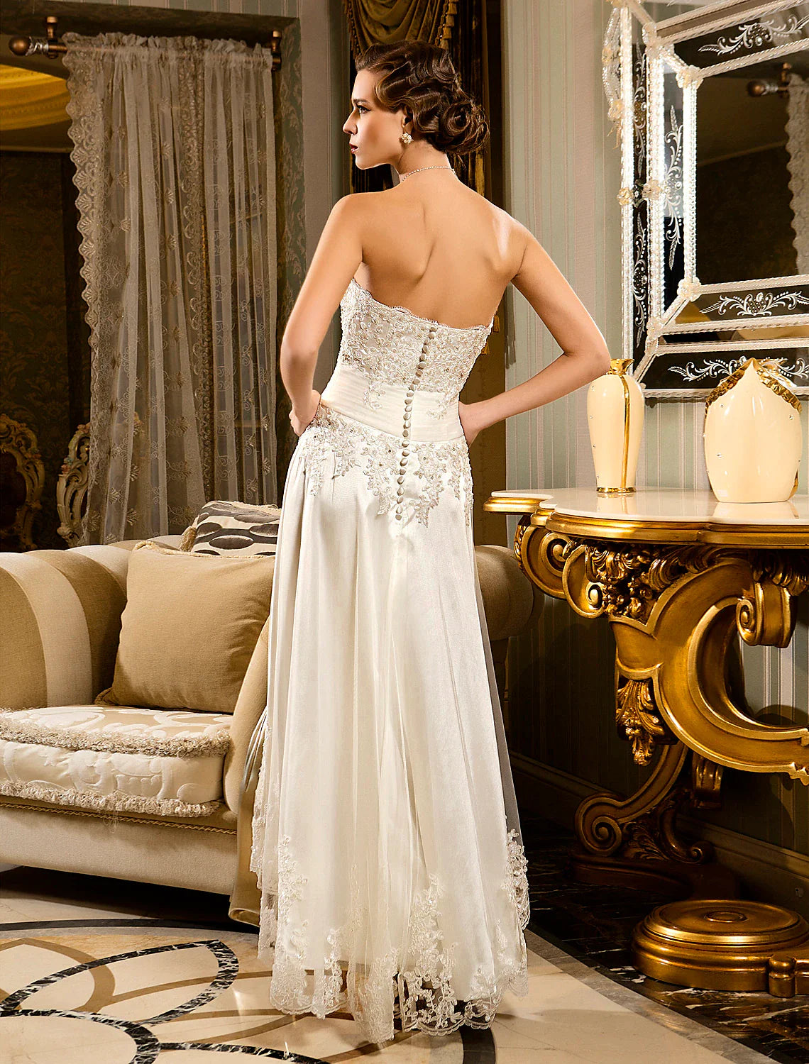 Detailed view of the asymmetrical lace skirt and button accents on the bridal gown.