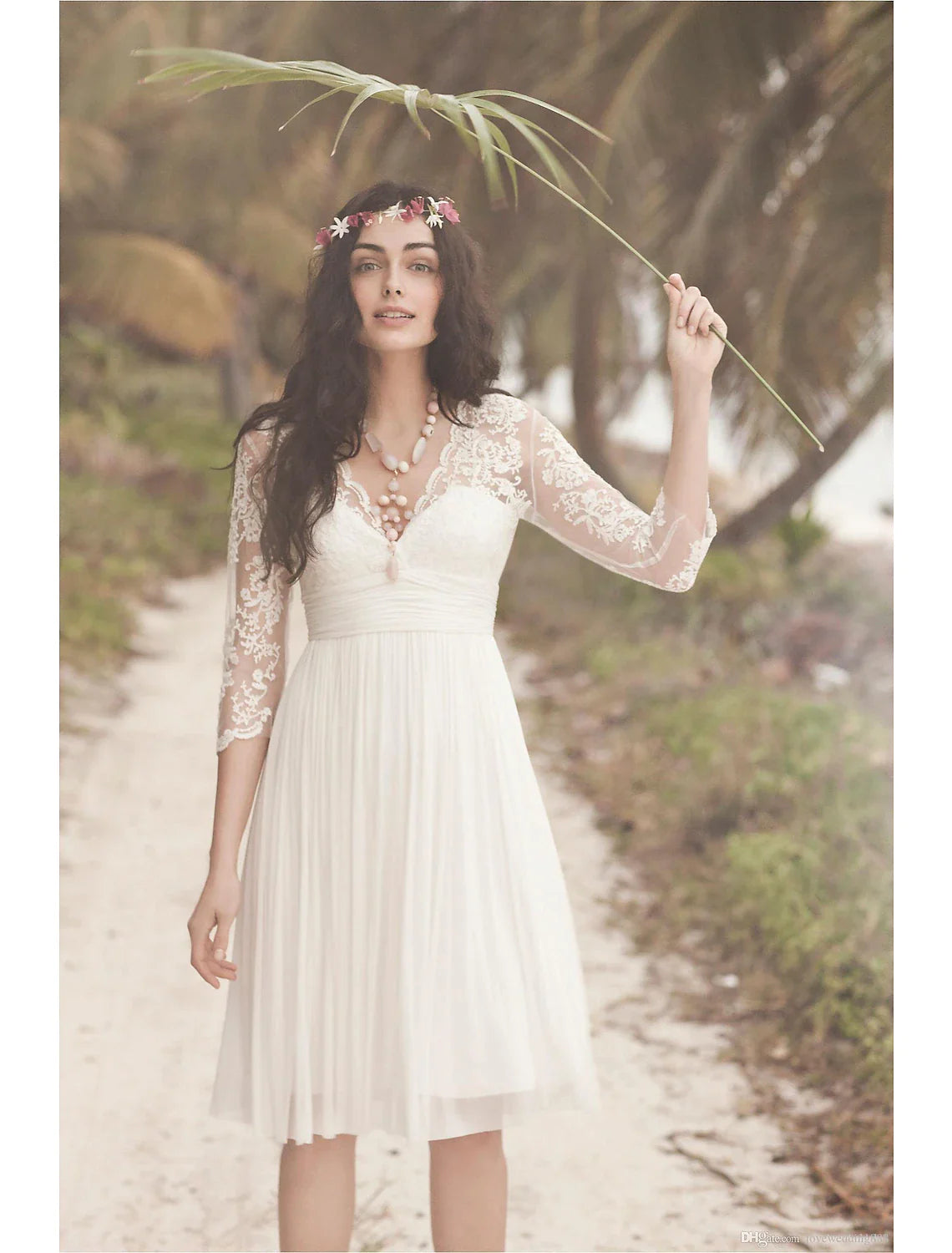 Back view of a model in a white knee-length A-line dress featuring an open back and 3/4 sleeves.