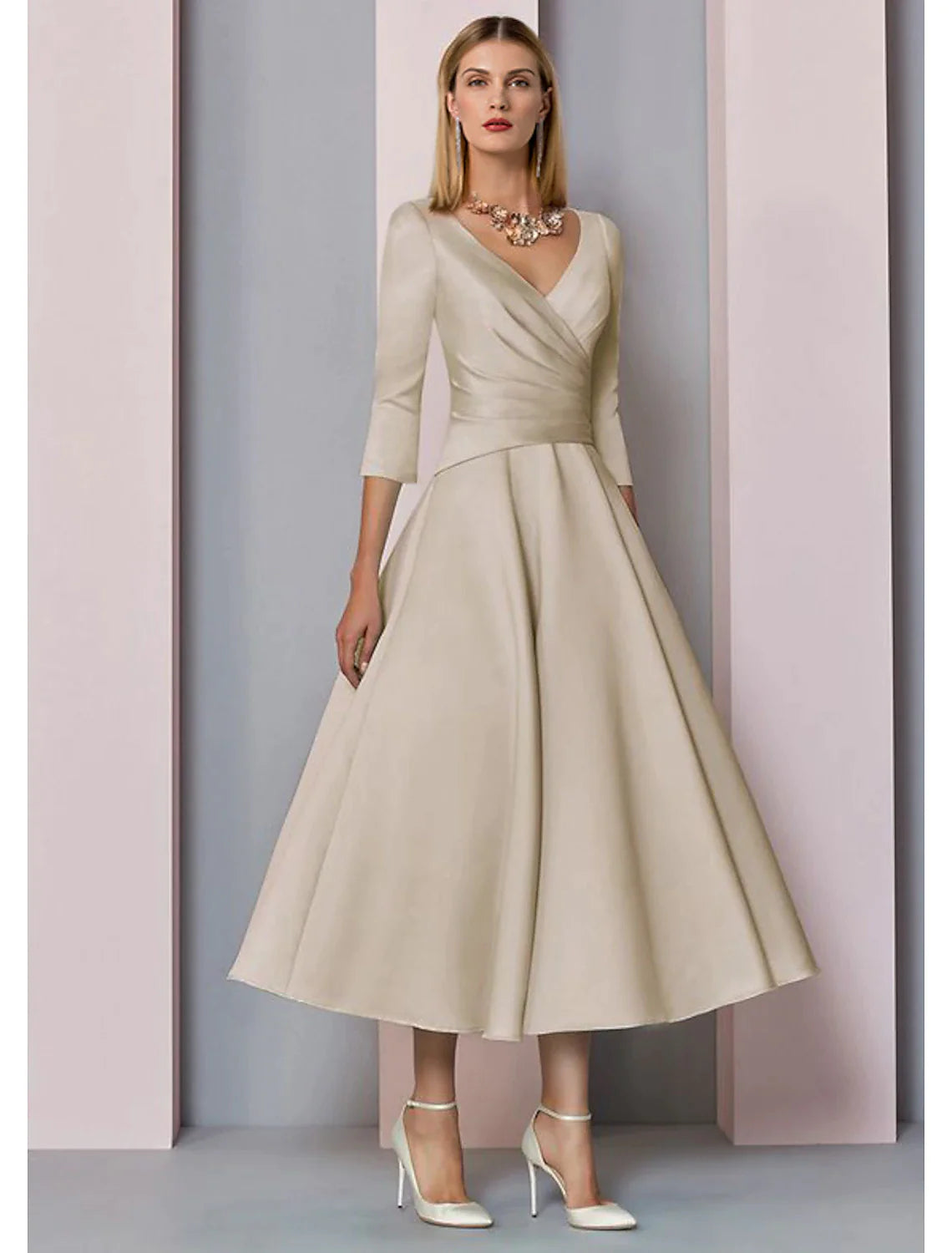 Model wearing an elegant A-line V-neck 3/4 sleeve tea-length satin dress with pleats.
