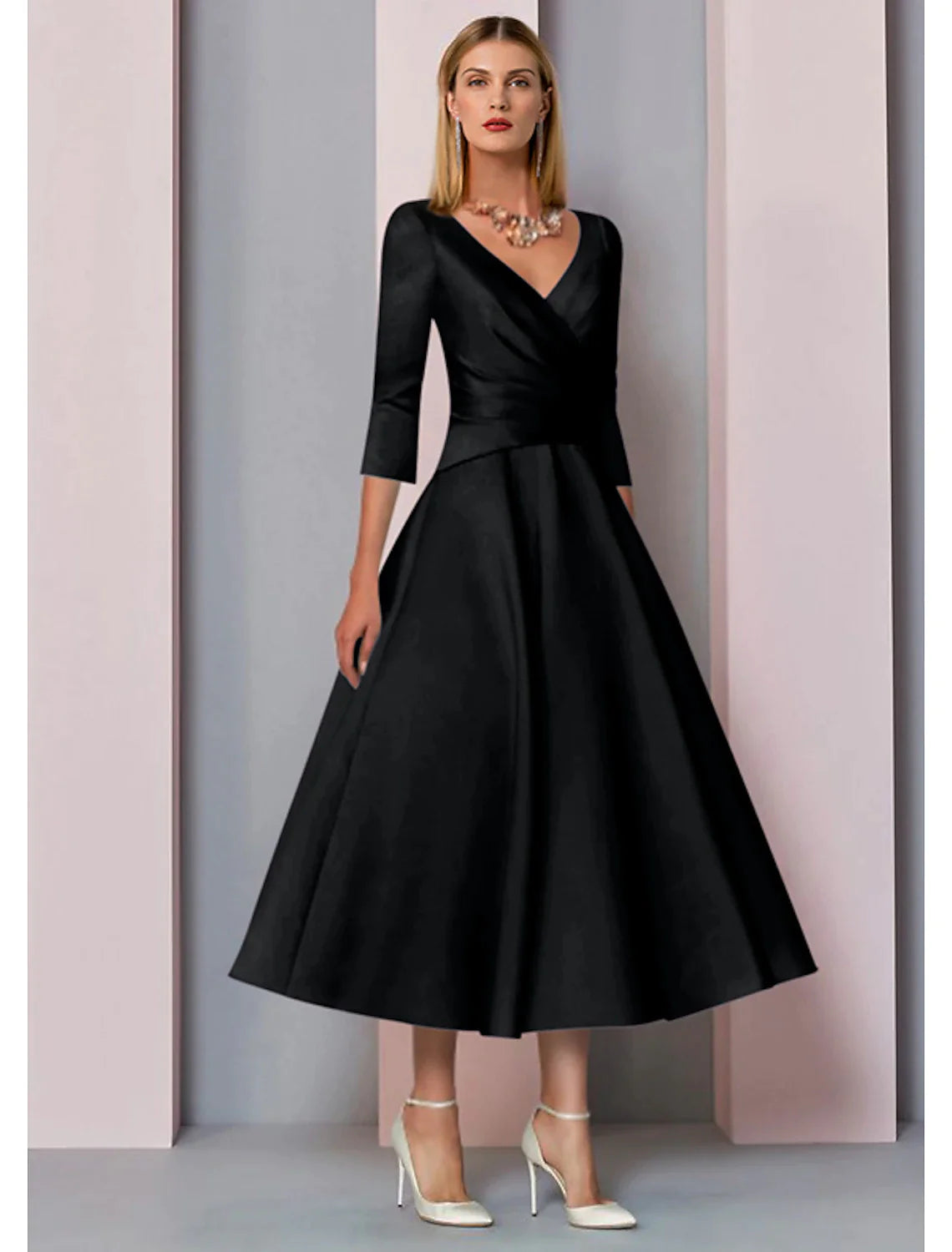 Model posing in the A-line tea-length mother of the bride dress.