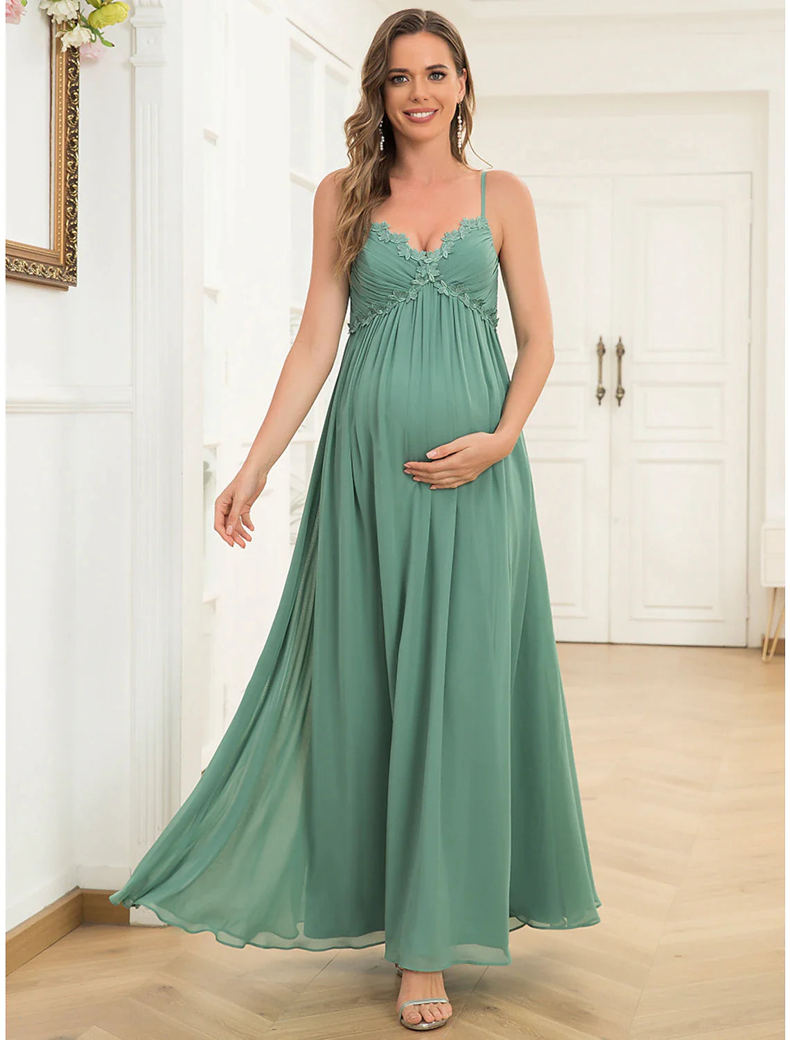 Woman wearing an elegant A-line V-neck chiffon evening gown with draping.