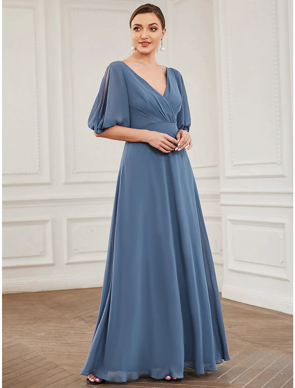 Woman in a light blue A-line V-neck chiffon gown with half sleeves and pleats.