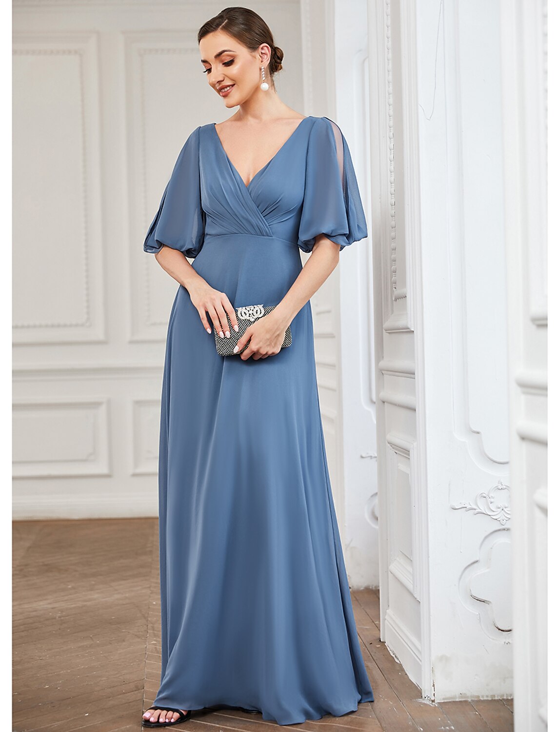 Woman posing elegantly in a light blue floor-length A-line gown.