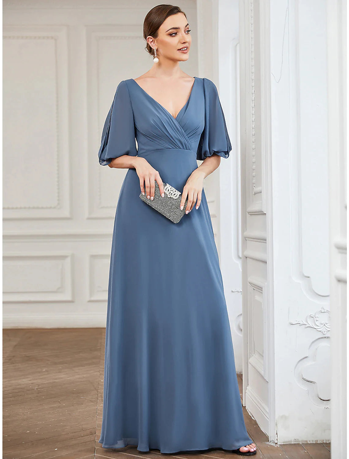Back view of a light blue A-line V-neck gown with flowing chiffon.