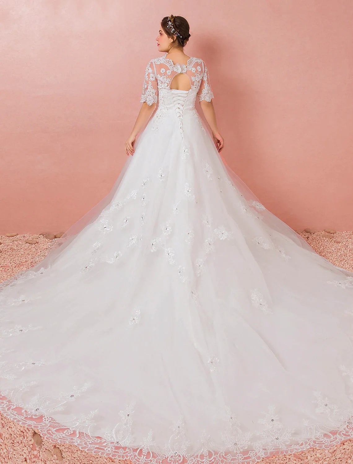 Back view of the satin bridal gown, showcasing the long cathedral train and lace details.