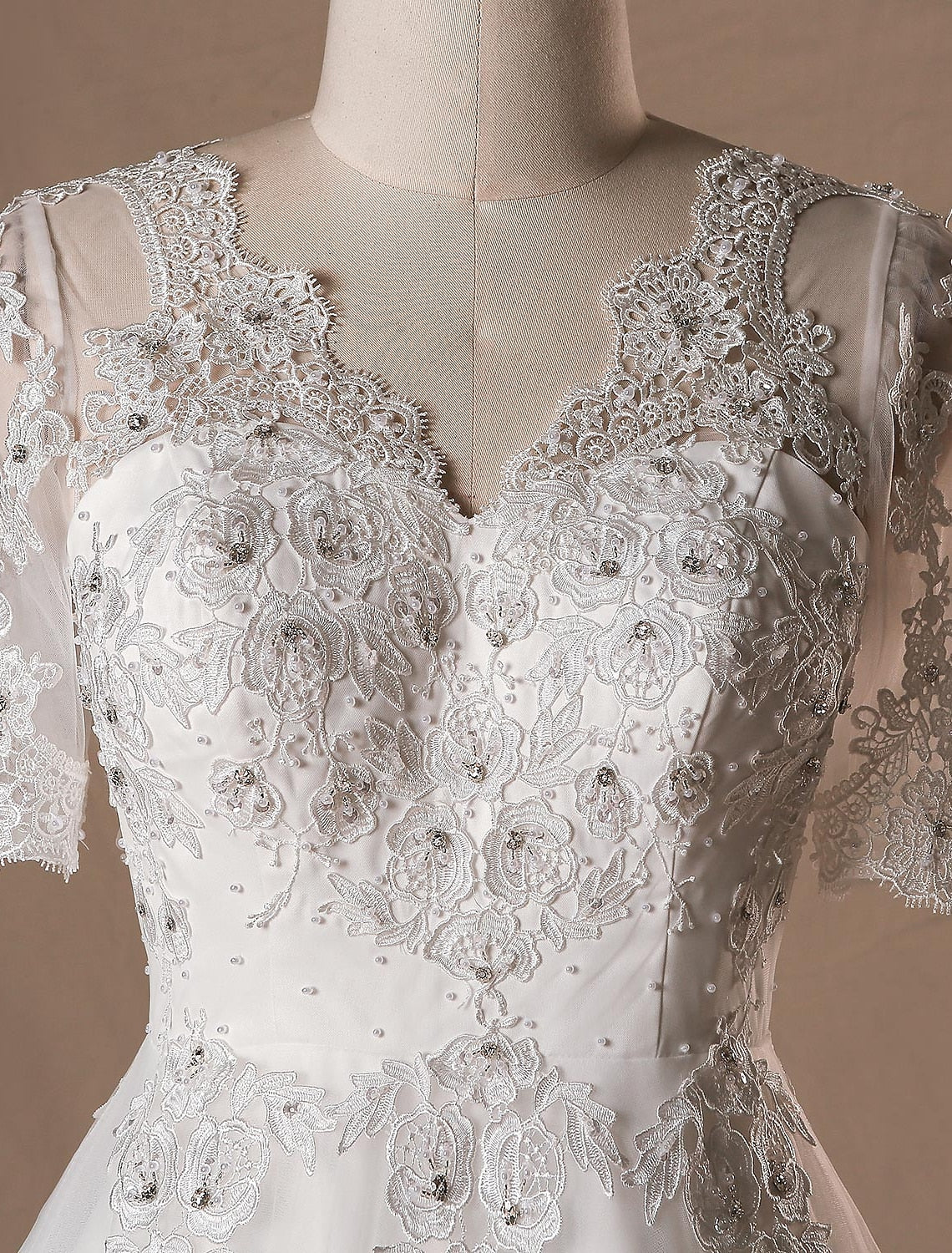 Detailed view of the intricate lace and crystal embellishments on the wedding dress.