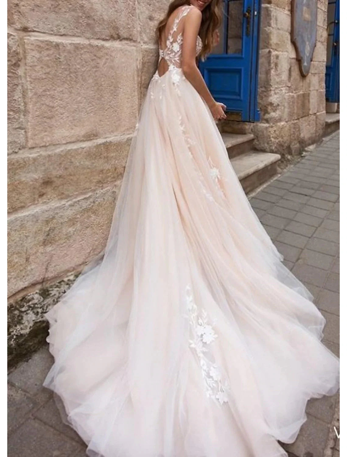 Side profile of the A-line wedding dress, highlighting its flowing silhouette and appliques.