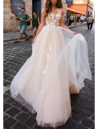 Model posing in the sleeveless A-line wedding dress on a sandy beach.