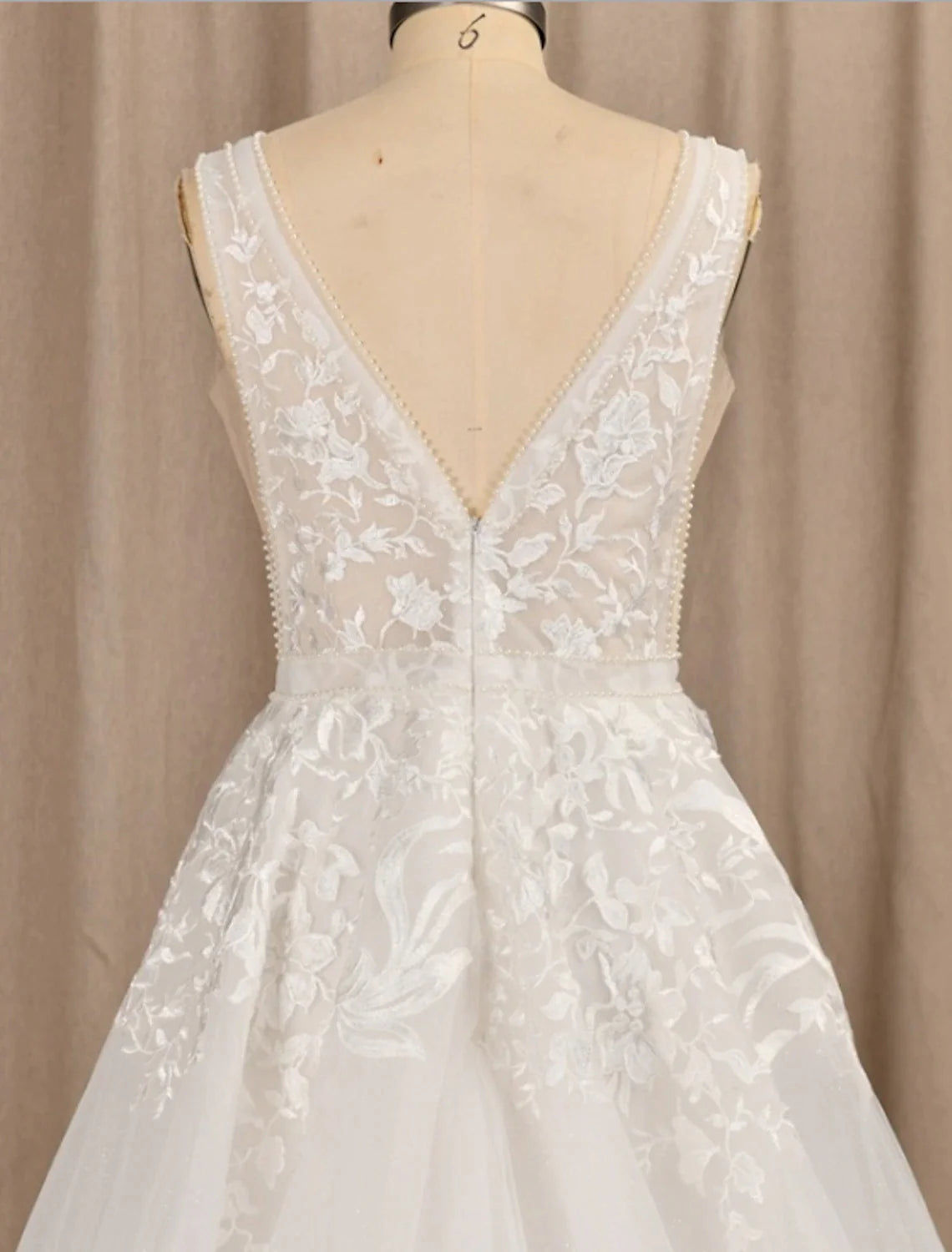 Close-up of delicate lace and floral appliques on the bridal gown.