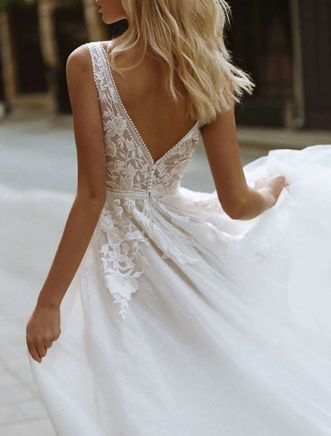 Side profile of the V-Neck sleeveless bridal gown with appliques.