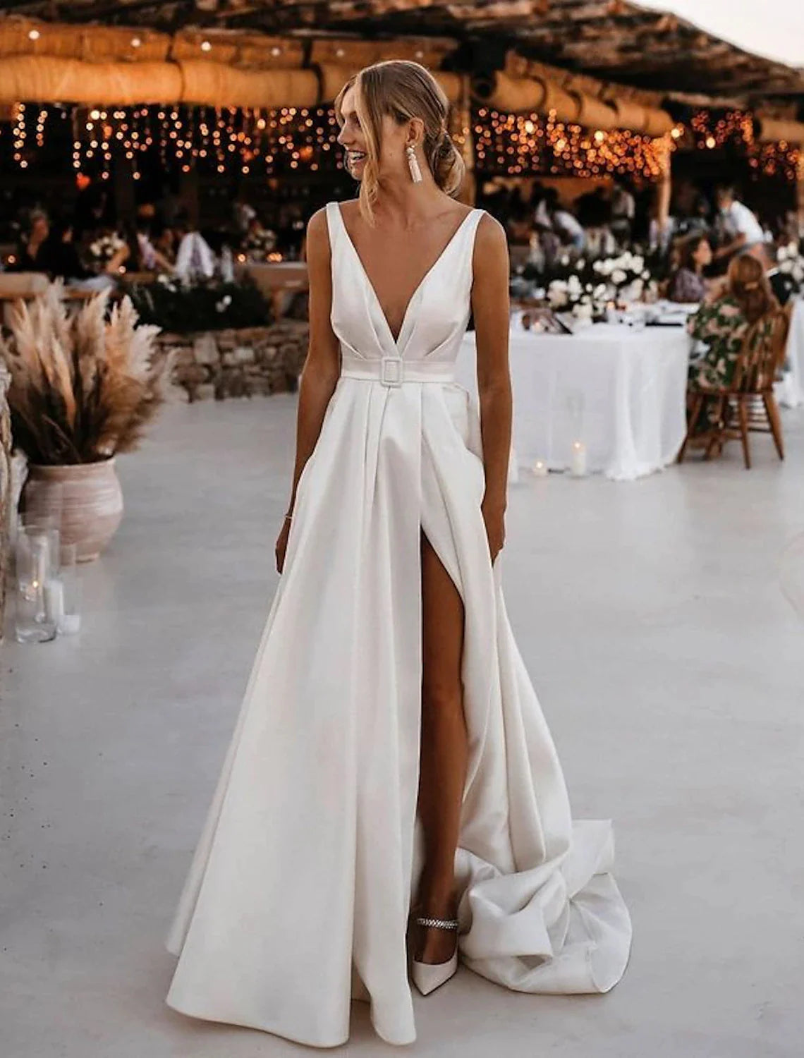 Model wearing A-line V-neck satin beach wedding gown with sashes.