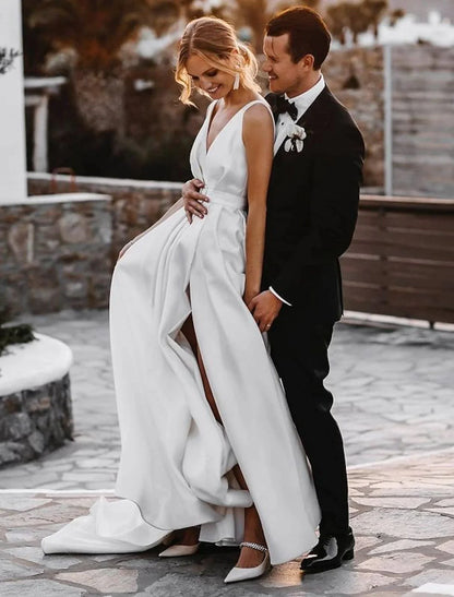 Side profile of bride in V-neck satin wedding dress on beach.