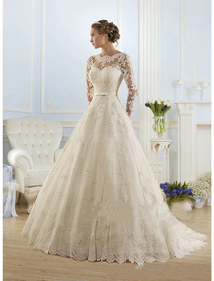 Bride in elegant white lace ball gown wedding dress with illusion neck and long sleeves.