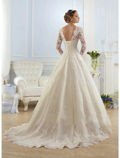 Back view of a bride in a white ball gown wedding dress with a court train and lace appliques.