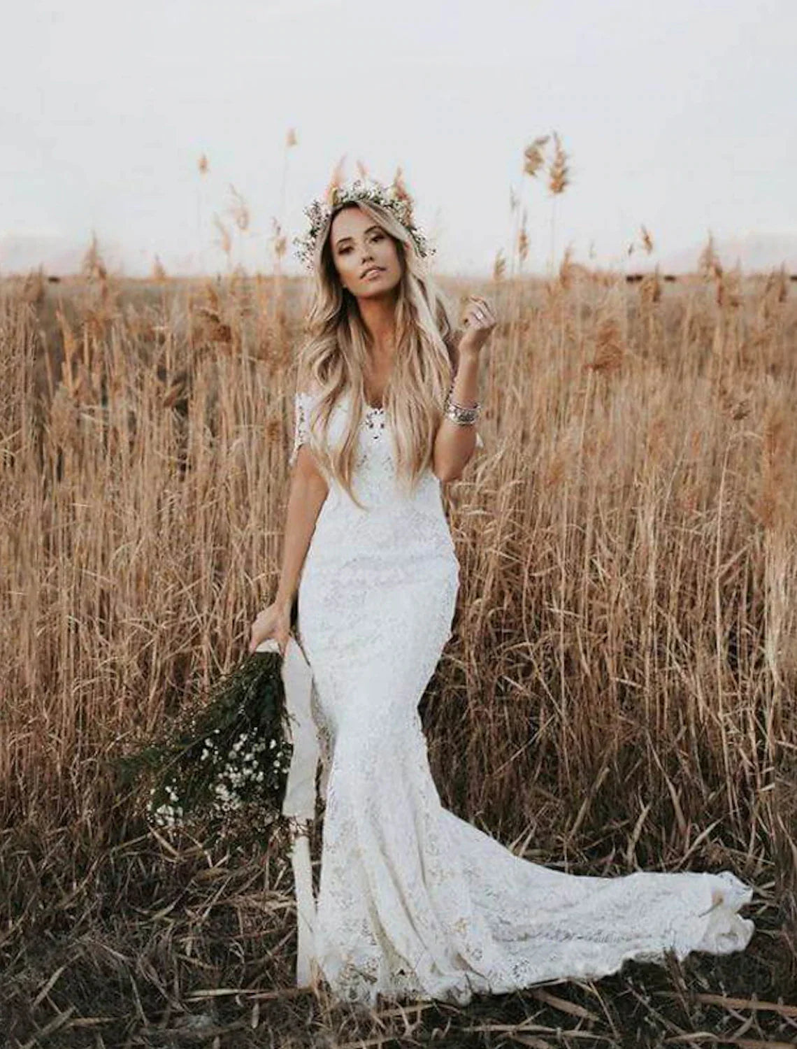 Model wearing an elegant off-shoulder mermaid wedding gown with lace appliques.