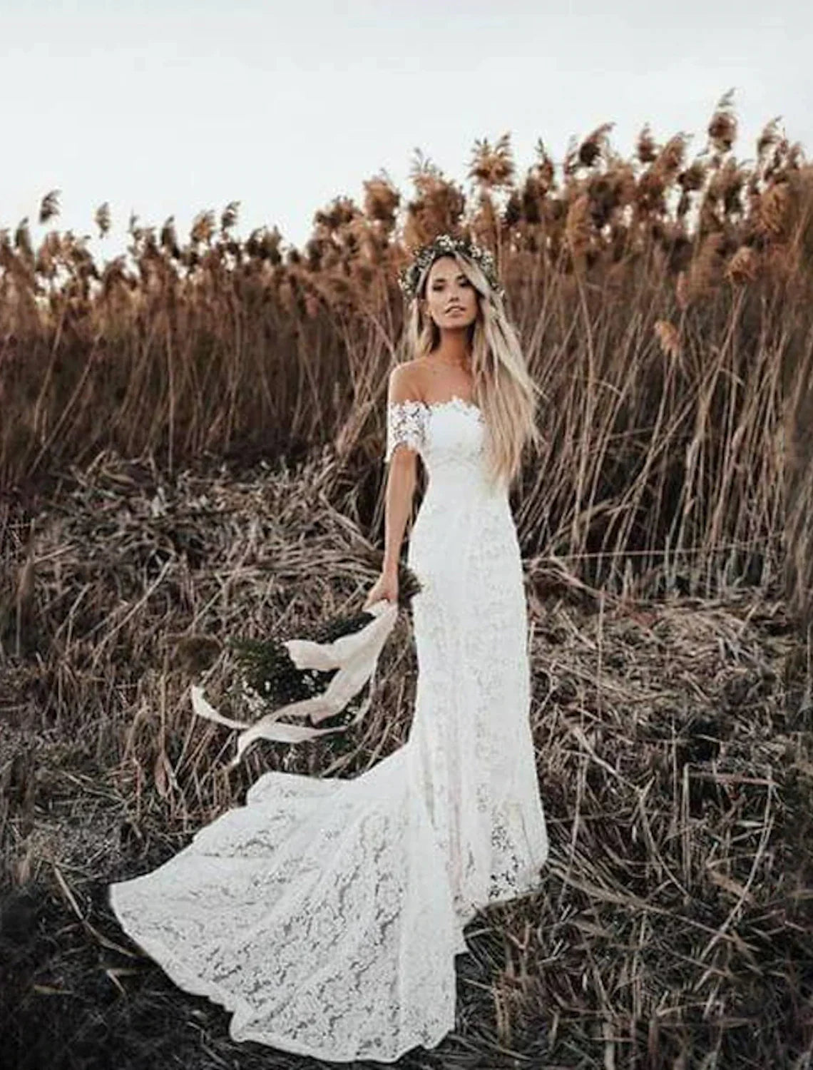 Full length view of the mermaid wedding gown with intricate lace and chapel train.