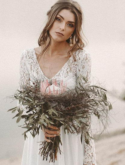 Model wearing an elegant A-line V-neck long-sleeve chiffon wedding dress with a sweep train outdoors.