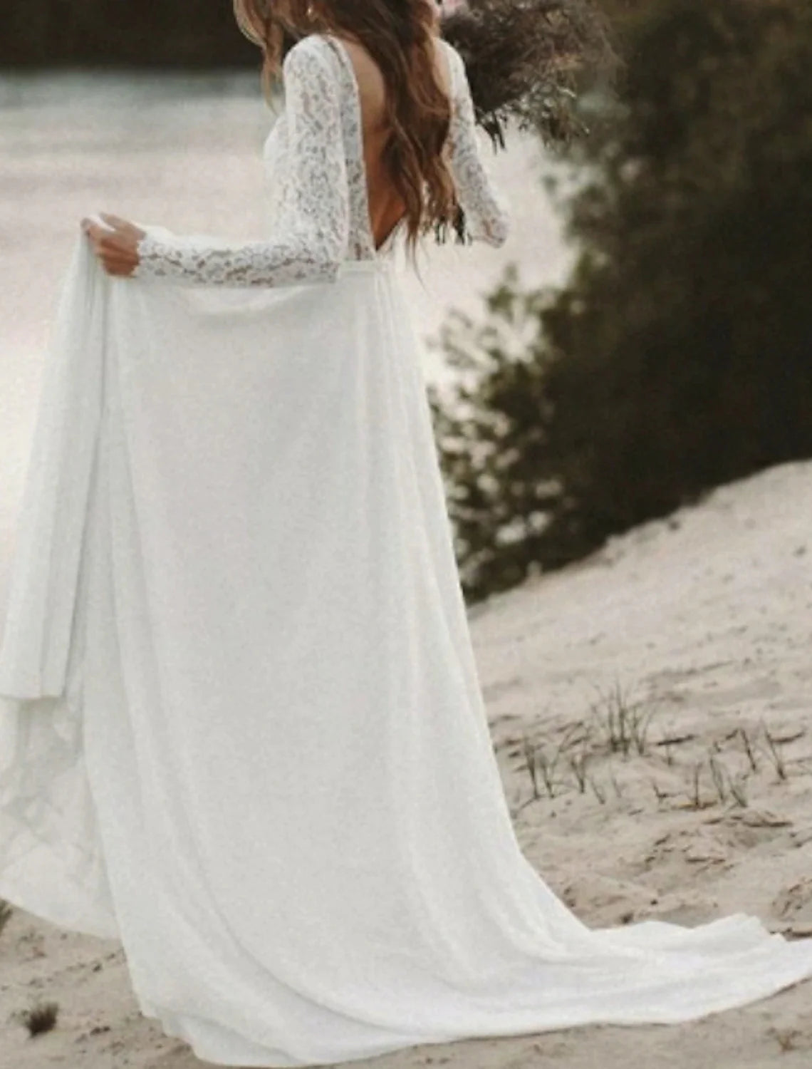 Detail of the flowing chiffon fabric and the delicate sweep train of the bridal gown.