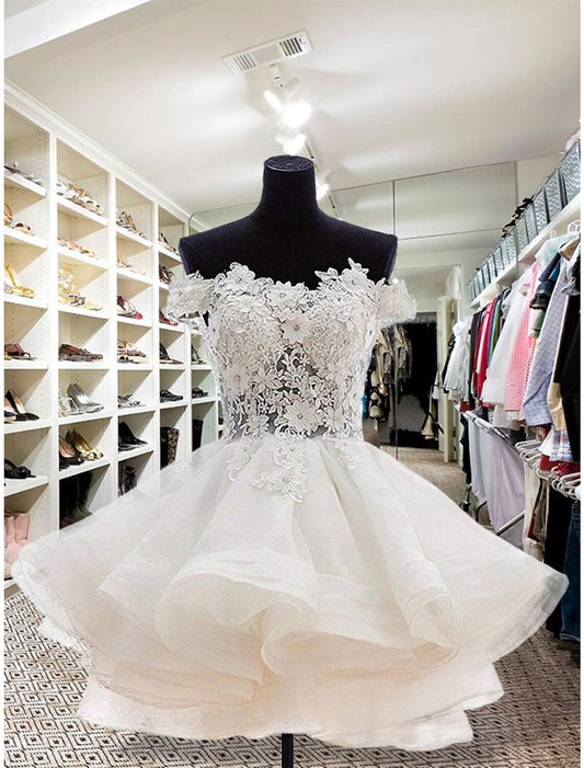 Front view of a short floral organza mini homecoming dress with appliques and buttons.