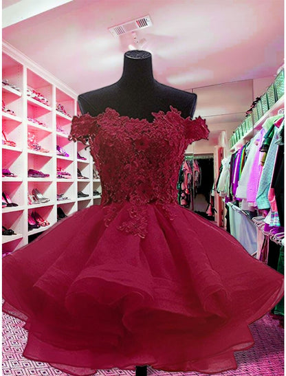 Side view of a strapless floral organza mini dress, showcasing appliques.