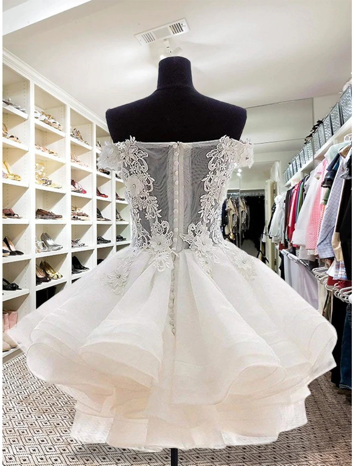 Back view of a sleeveless floral organza mini dress with button details.
