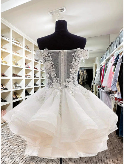 Back view of a sleeveless floral organza mini dress with button details.